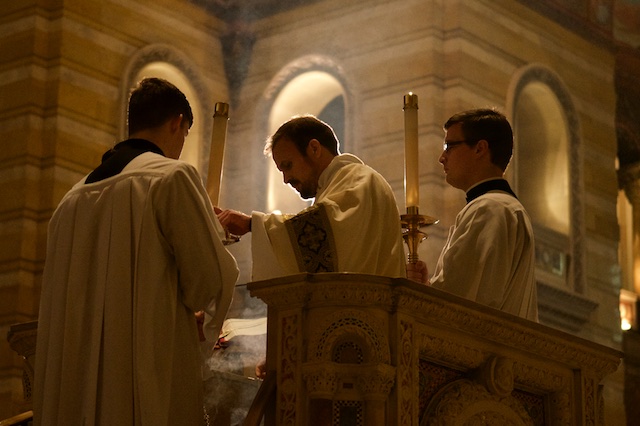 Deacon incensing the Book of Gospels with light in background at Memorial Mass for Justice Antonin Scalia