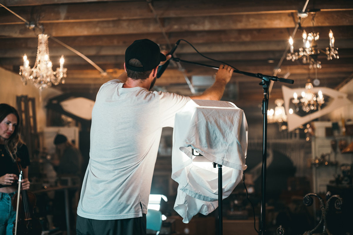 Man working on boom microphone shotgun recording setup for video