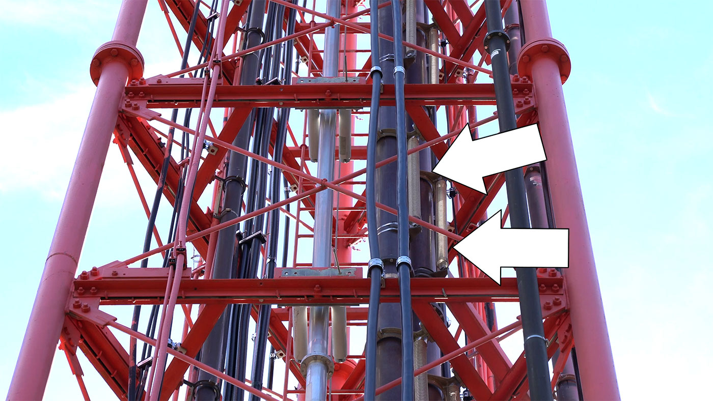 Guyed tower with hard line FM transmission coax held with spring hangers