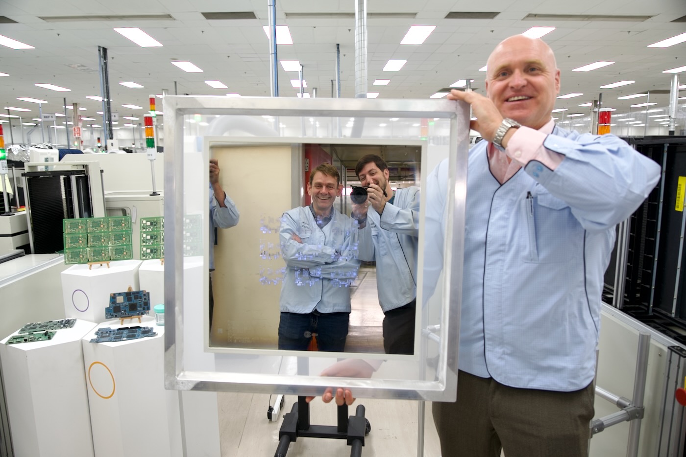 Andrew Puntan holds solder screen for Pi 3 B while Jeff Geerling and Gordon Hollingworth look on