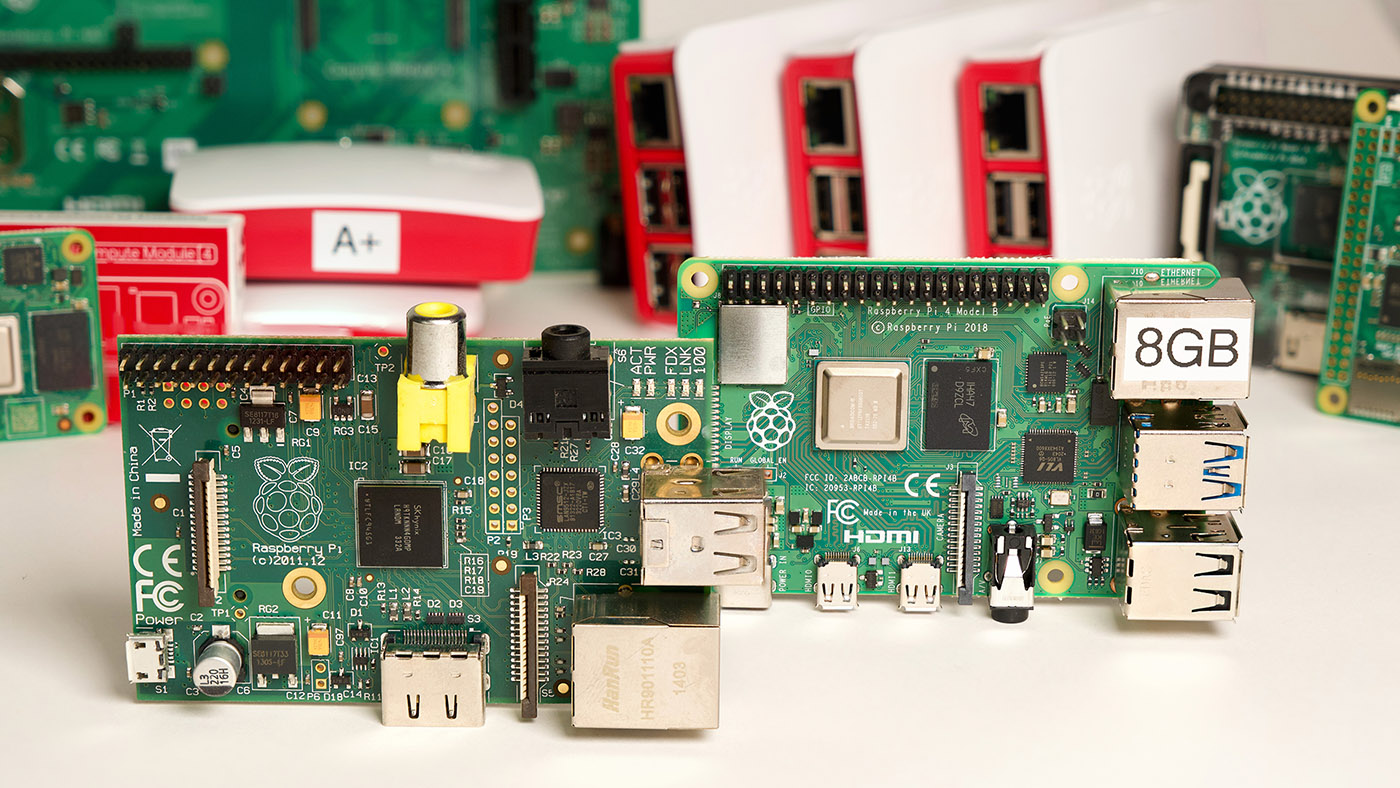 Original Raspberry Pi model B and Pi 4 model B with old Pis in background