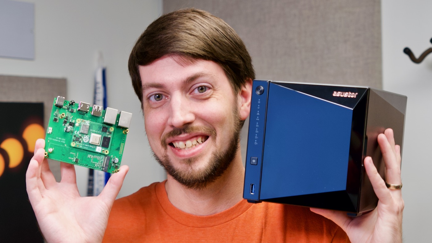 Jeff Geerling holding Raspberry Pi Radxa Taco NAS board and ASUSTOR Drivestor 4 Pro