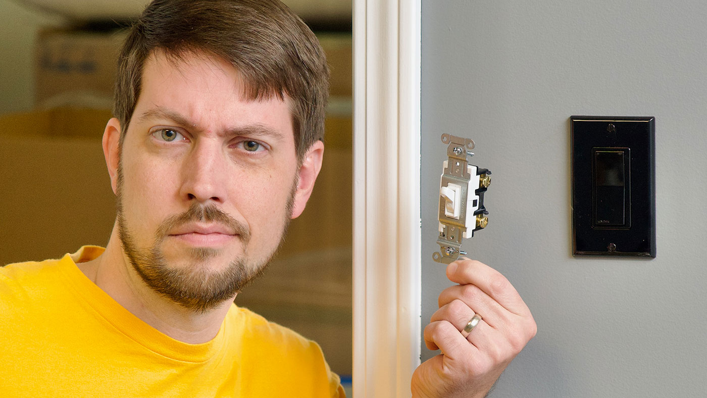 Jeff Geerling holds a dumb not smart light switch